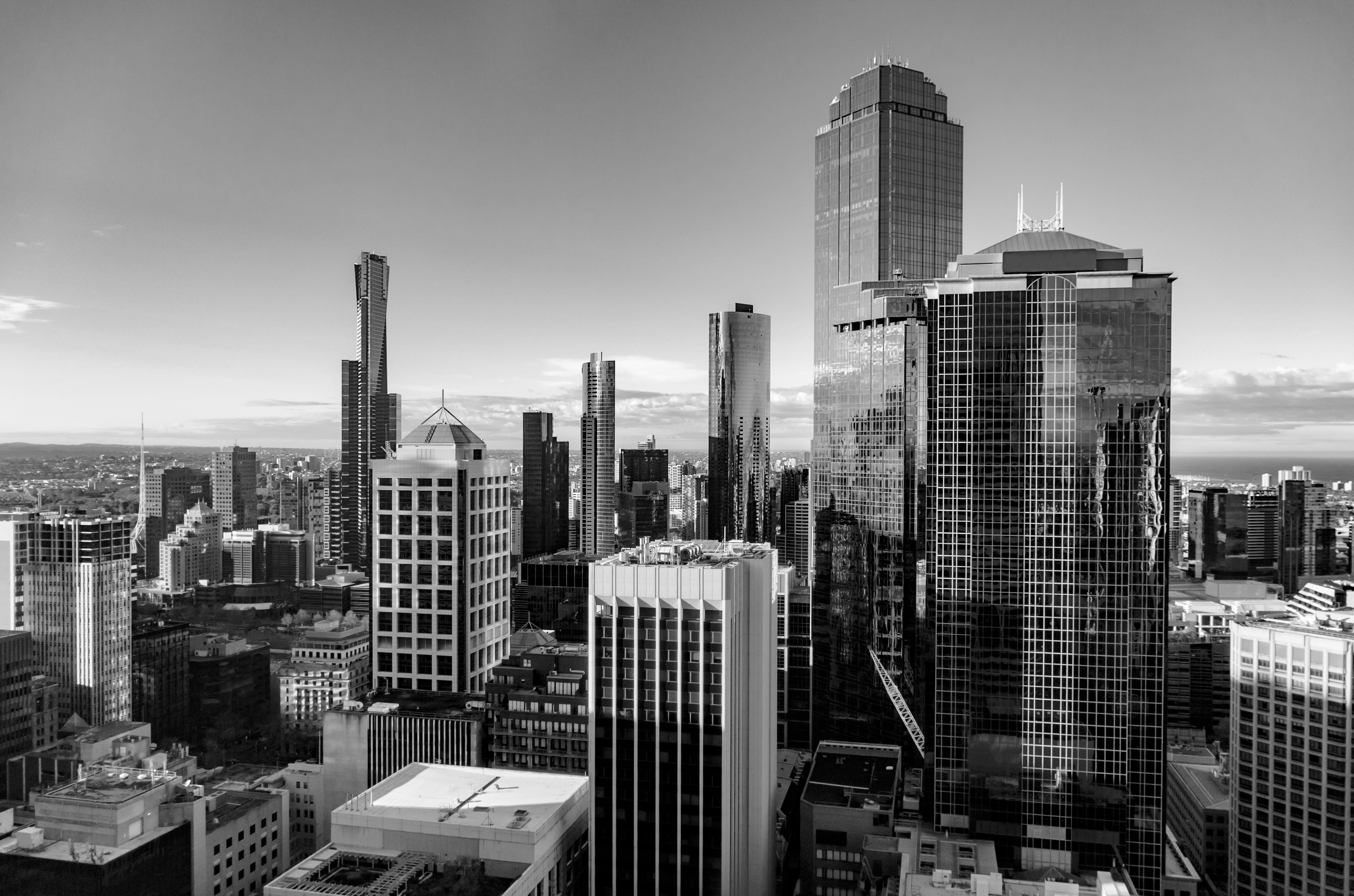 Black and white city skyline with tall modern skyscrapers under a clear sky.